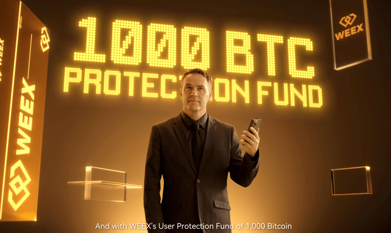 Michael Owen stands in a golden room with a smartphone in his hand. Behind him, the words “1000 BTC Protection Fund” glow in large yellow letters, surrounded by WEEX logos.